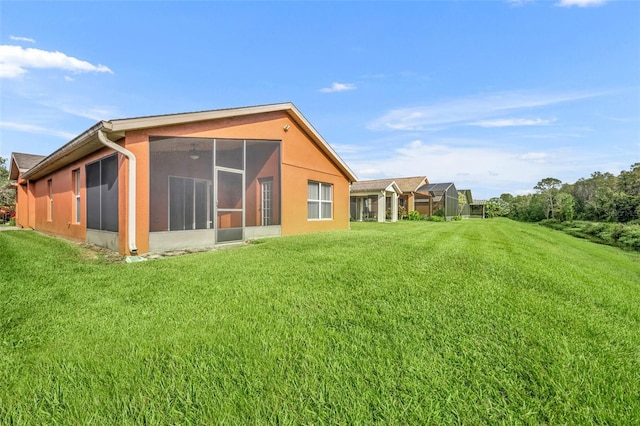 rear view of property featuring a sunroom and a yard