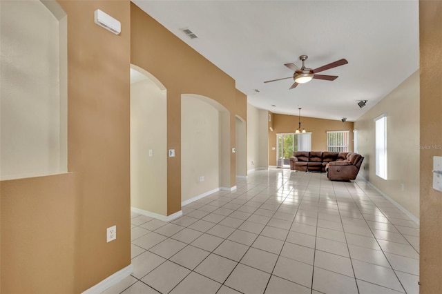 interior space with vaulted ceiling, ceiling fan, and light tile patterned floors