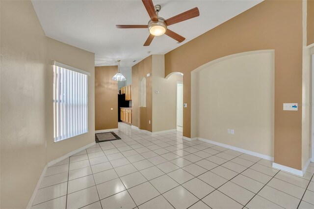 540 Grand Canal Dr, Kissimmee, FL 34759 - spare room featuring baseboards, a ceiling fan, arched walkways, and light tile patterned flooring