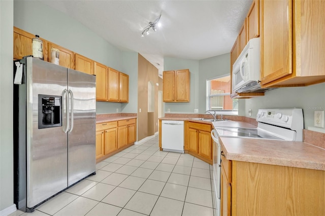 kitchen featuring light brown cabinetry, white appliances, sink, and light tile patterned floors