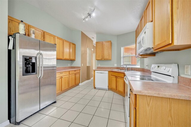 540 Grand Canal Dr, Kissimmee, FL 34759 - kitchen with light brown cabinetry, a sink, light countertops, white appliances, and light tile patterned flooring