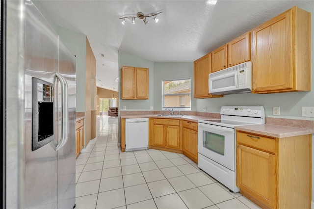 kitchen featuring light tile patterned flooring, lofted ceiling, sink, white appliances, and a textured ceiling