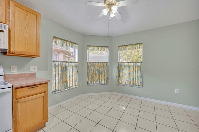 kitchen with ceiling fan, light brown cabinets, light tile patterned floors, and white appliances