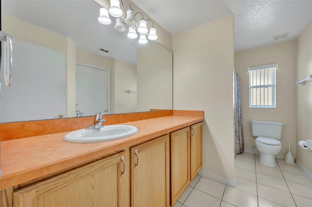 bathroom with tile patterned floors, a textured ceiling, vanity, and toilet