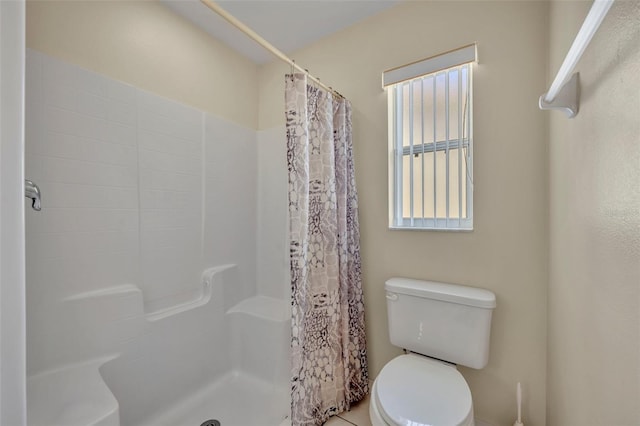 bathroom with a shower with curtain and toilet