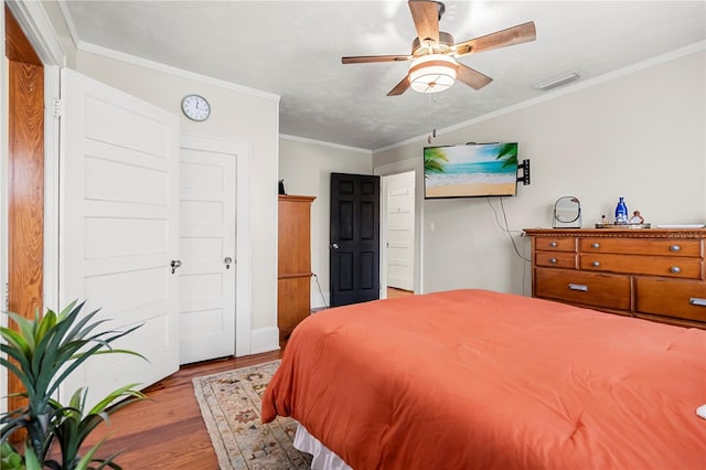 bedroom with crown molding, ceiling fan, and light hardwood / wood-style floors