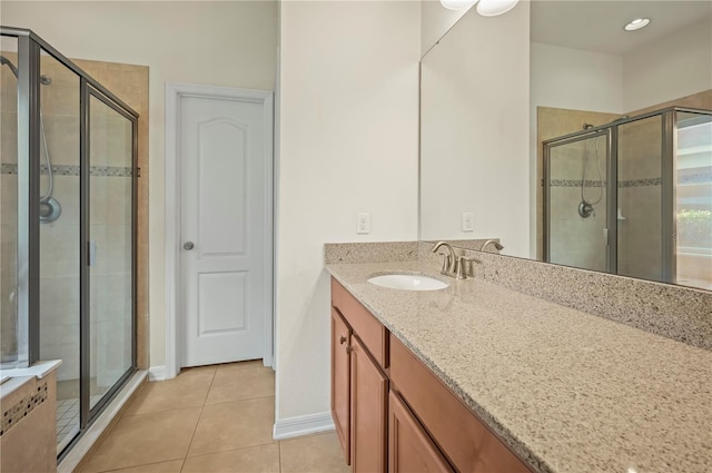 bathroom featuring tile patterned flooring, vanity, and a shower with door