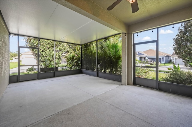 unfurnished sunroom with ceiling fan and plenty of natural light