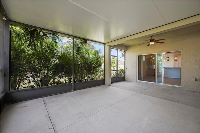 unfurnished sunroom with ceiling fan