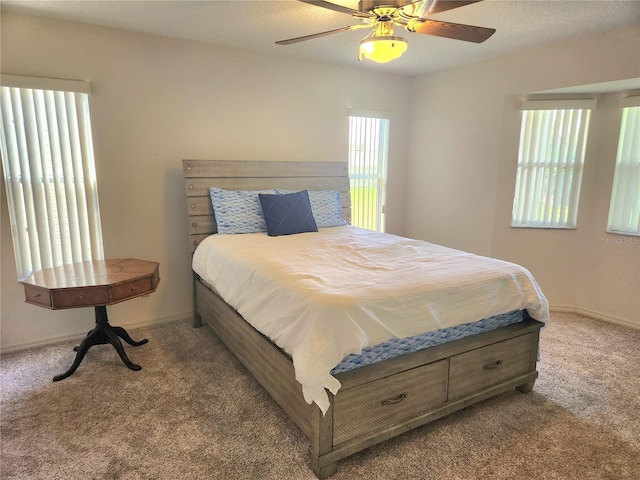 carpeted bedroom featuring ceiling fan and baseboards