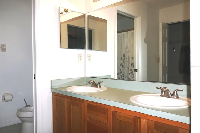 full bath featuring toilet, double vanity, and a sink