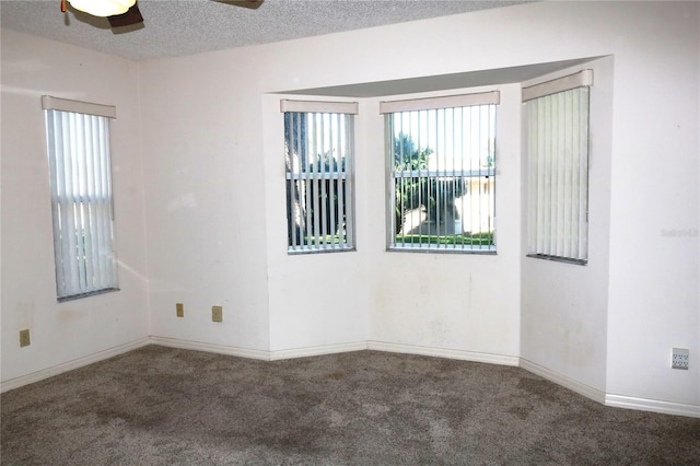 spare room featuring carpet floors, a ceiling fan, baseboards, and a textured ceiling