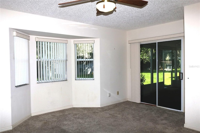 carpeted empty room featuring a textured ceiling, a ceiling fan, and baseboards