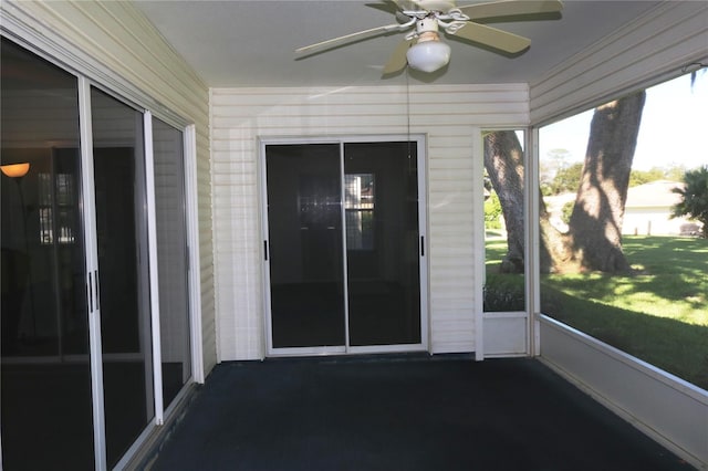 unfurnished sunroom featuring a ceiling fan