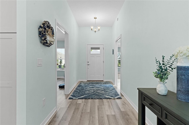 foyer with light hardwood / wood-style floors and an inviting chandelier