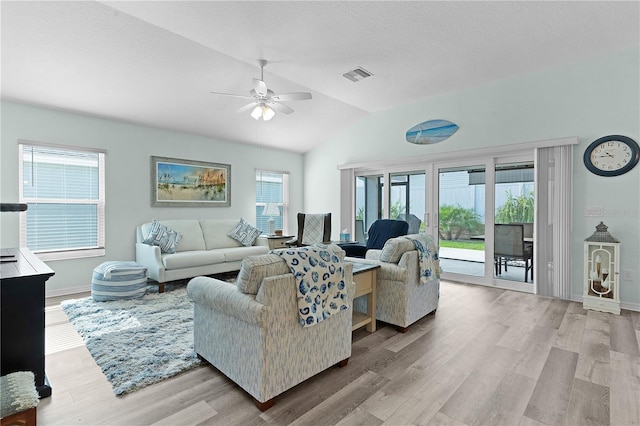 living room featuring ceiling fan, a textured ceiling, lofted ceiling, and light hardwood / wood-style floors