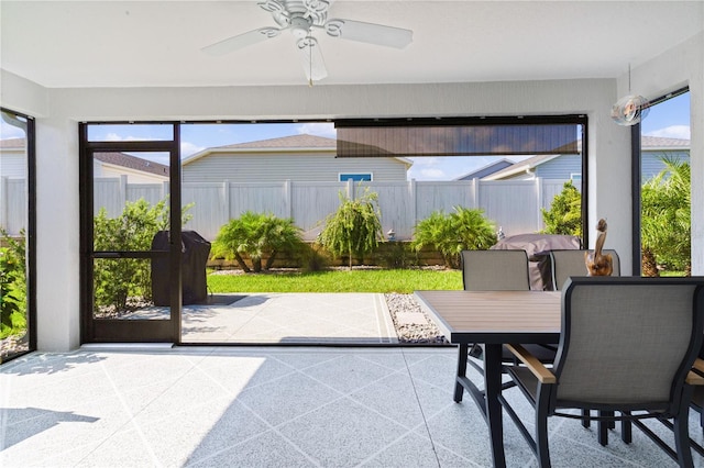 sunroom / solarium featuring ceiling fan and plenty of natural light