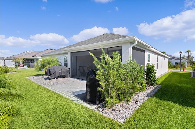 rear view of property with a sunroom and a lawn