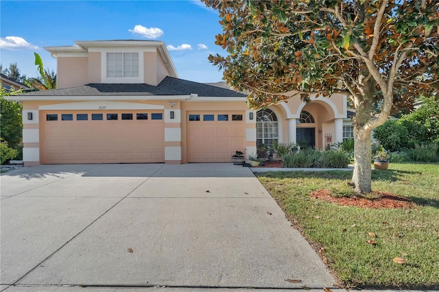 view of front of property featuring a garage and a front lawn