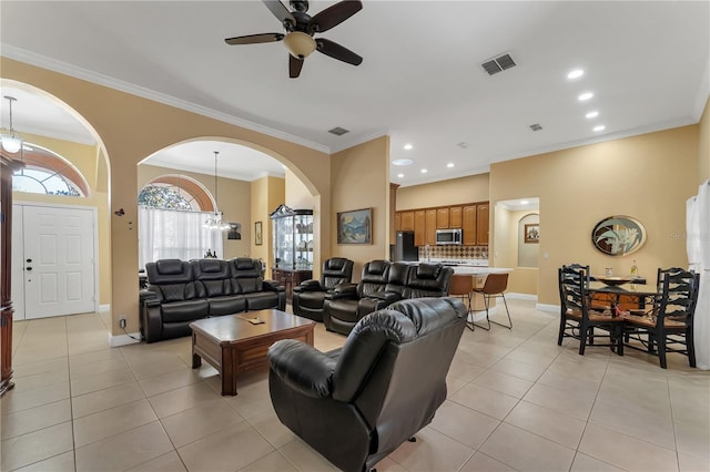 living room featuring crown molding, ceiling fan with notable chandelier, and light tile patterned floors