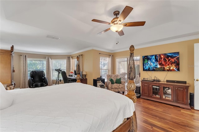 bedroom with ceiling fan, crown molding, hardwood / wood-style floors, and multiple windows