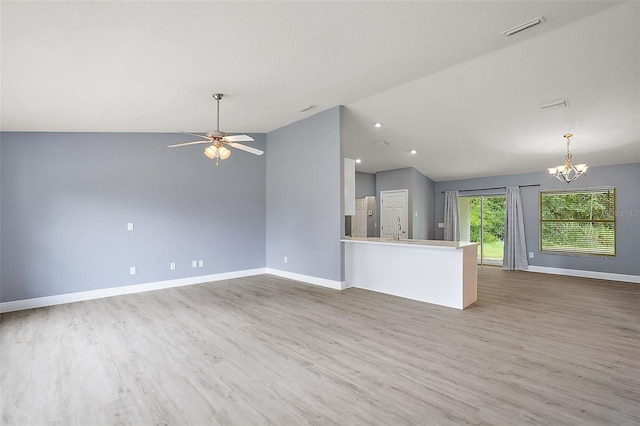 unfurnished living room with ceiling fan with notable chandelier, sink, vaulted ceiling, and wood-type flooring