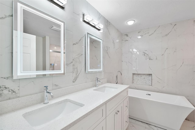 bathroom with vanity, tile walls, and a bath