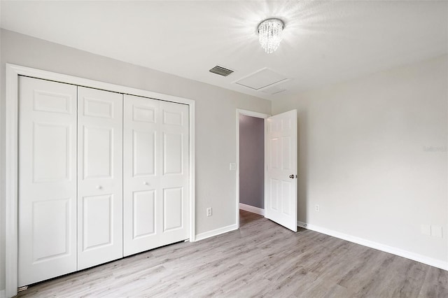 unfurnished bedroom with light wood-type flooring and a closet