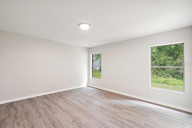 unfurnished room with light hardwood / wood-style floors and a healthy amount of sunlight