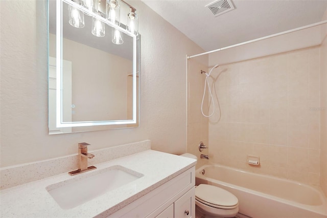 full bathroom featuring tiled shower / bath, vanity, and toilet