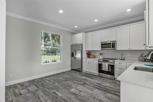 kitchen with sink, appliances with stainless steel finishes, white cabinets, and light hardwood / wood-style floors