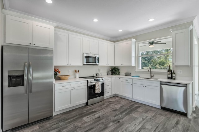 kitchen with ornamental molding, white cabinets, stainless steel appliances, and sink