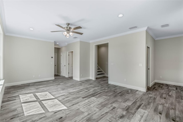 empty room featuring ornamental molding, light wood-type flooring, and ceiling fan