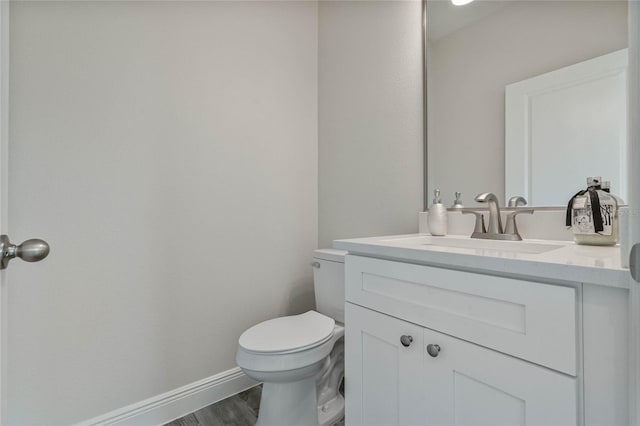 bathroom with vanity, hardwood / wood-style floors, and toilet