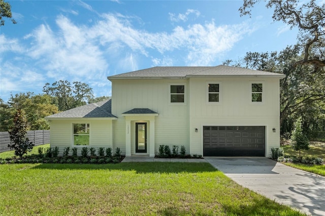 view of property featuring a front yard and a garage