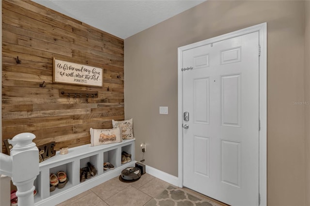 mudroom featuring wood walls and light tile patterned flooring