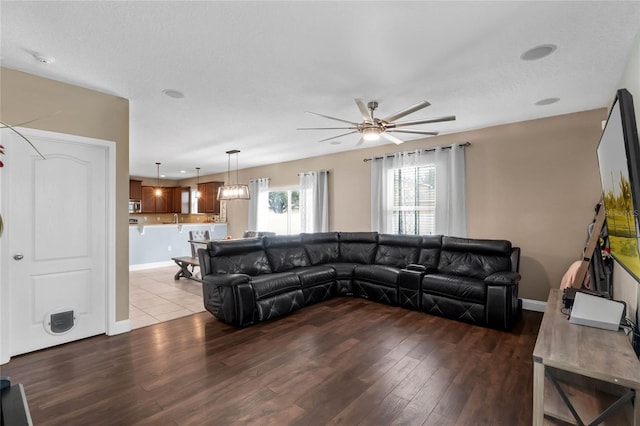 living room with light wood-type flooring, a textured ceiling, and ceiling fan