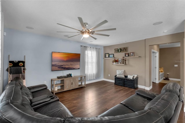 living room with a textured ceiling, dark hardwood / wood-style floors, and ceiling fan