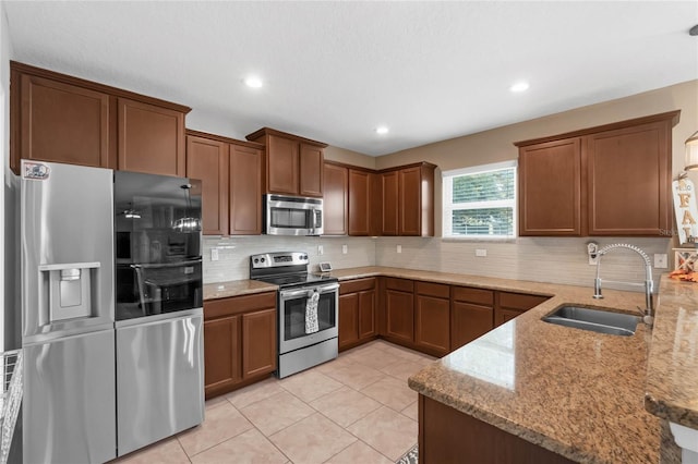 kitchen featuring light stone countertops, light tile patterned flooring, sink, and stainless steel appliances