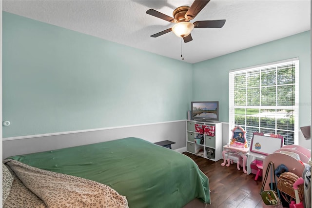 bedroom featuring ceiling fan, dark wood-type flooring, and a textured ceiling