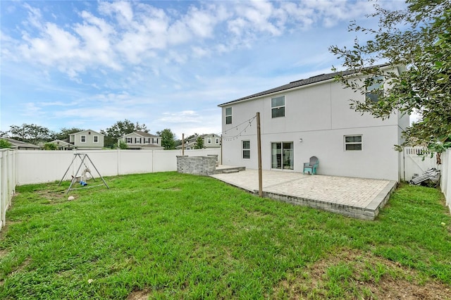 back of property featuring a lawn and a patio area