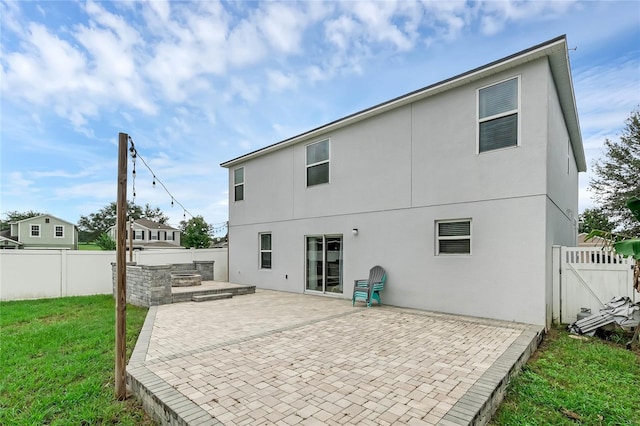 rear view of property featuring a yard and a patio area