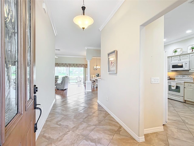 entryway with light tile patterned floors, ornamental molding, and decorative columns