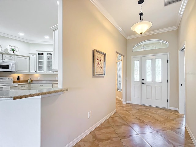 entryway featuring crown molding and light tile patterned flooring