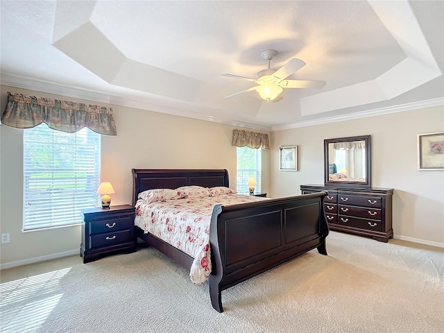 carpeted bedroom with ornamental molding, a raised ceiling, and ceiling fan