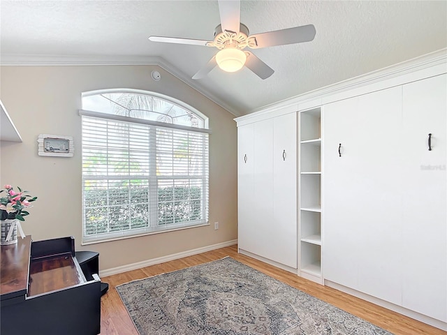 office space featuring lofted ceiling, a textured ceiling, ornamental molding, ceiling fan, and light hardwood / wood-style floors