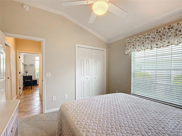 tiled bedroom featuring lofted ceiling, ornamental molding, a closet, and ceiling fan