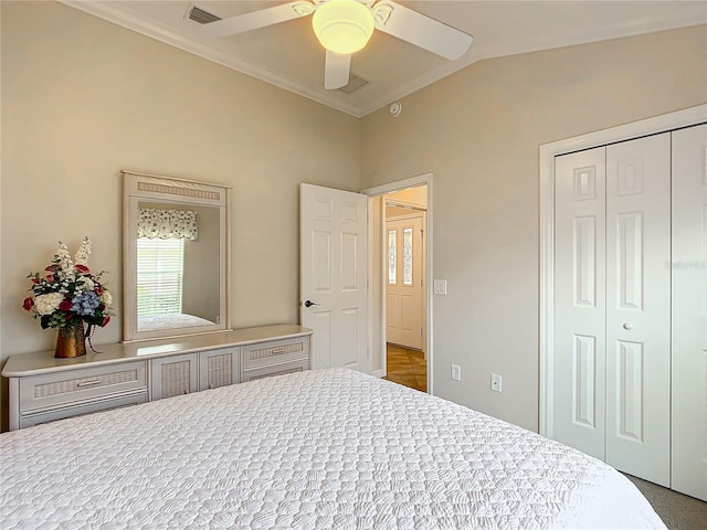 bedroom with crown molding, lofted ceiling, ceiling fan, and a closet