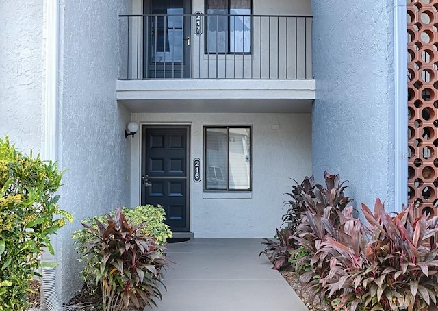 view of exterior entry featuring a balcony