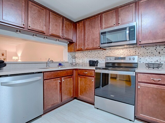 kitchen with sink, appliances with stainless steel finishes, and tasteful backsplash